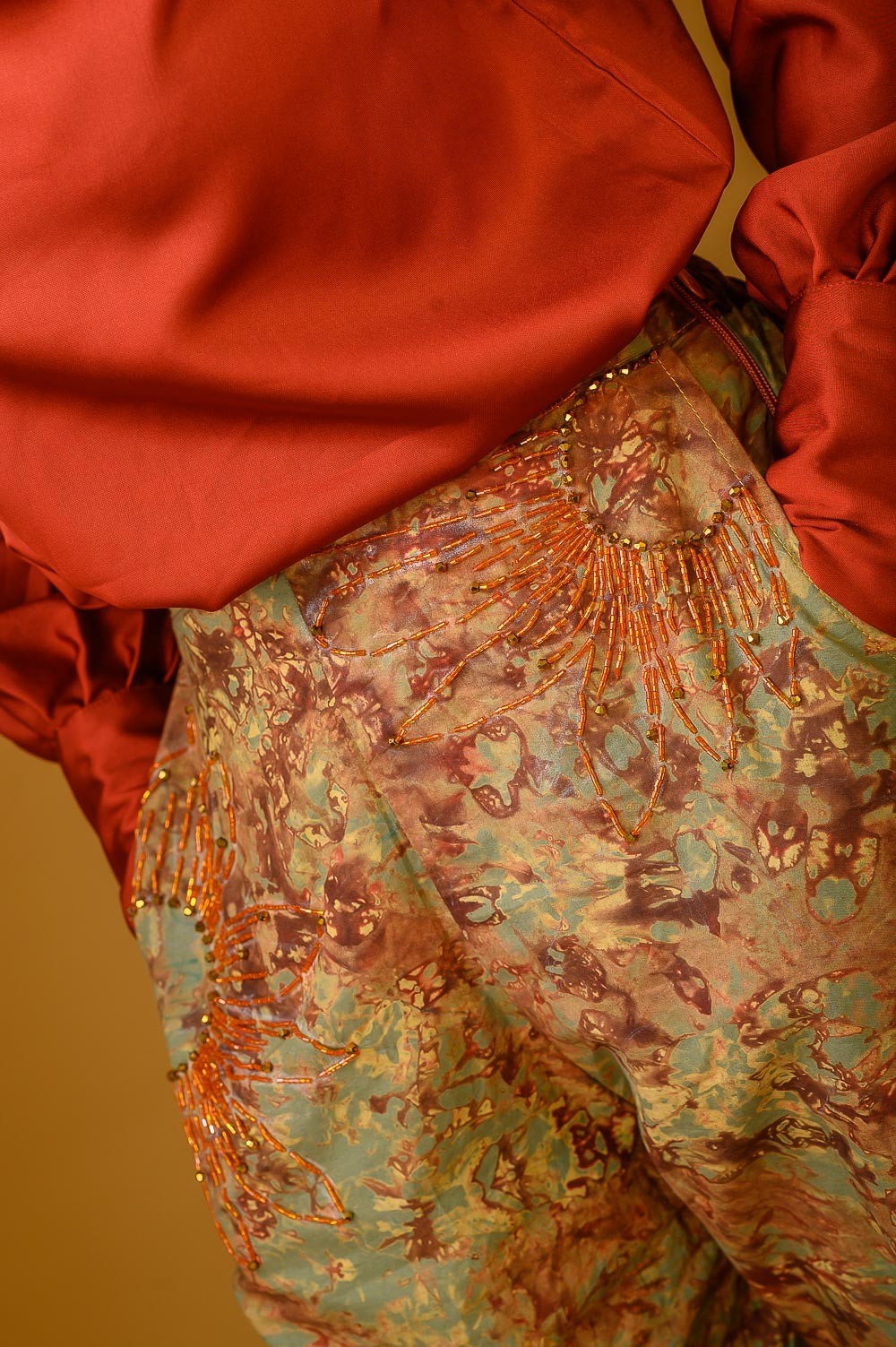 A zoomed in image of a lady wearing the Estelle set in Orange colour