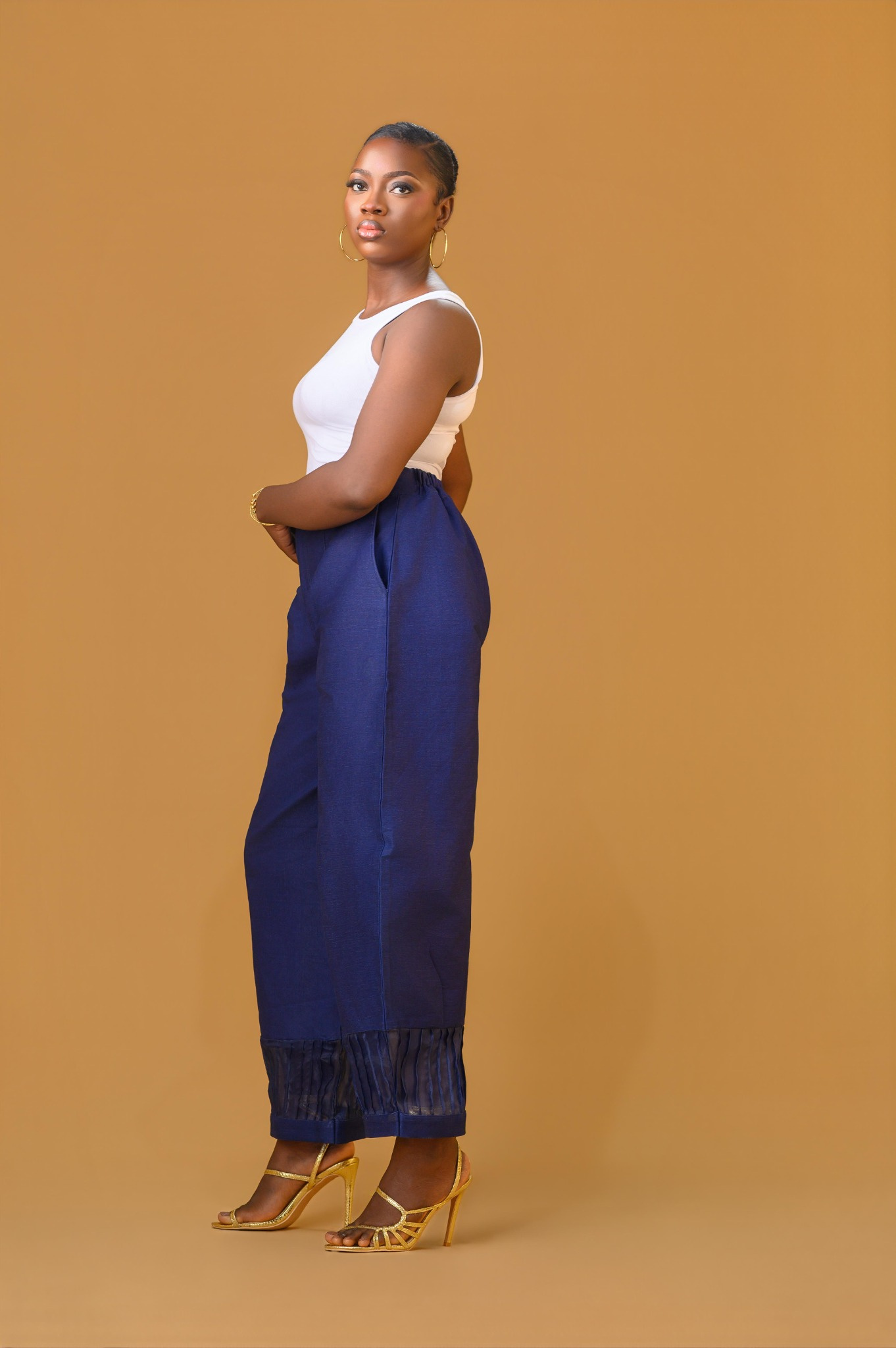 A lady wearing the Quinn barrel pant and a white tank top