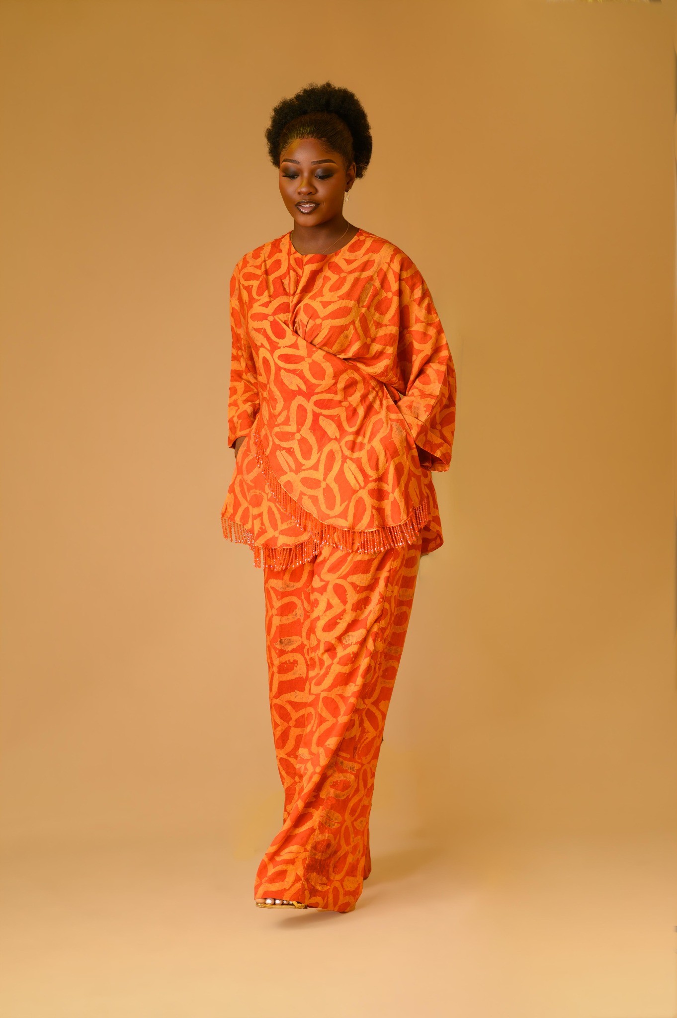 A lady wearing the Vivienne set in Orange colour