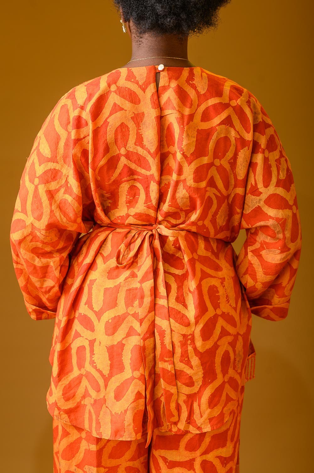 The back view of a lady wearing the Vivienne set in Orange colour