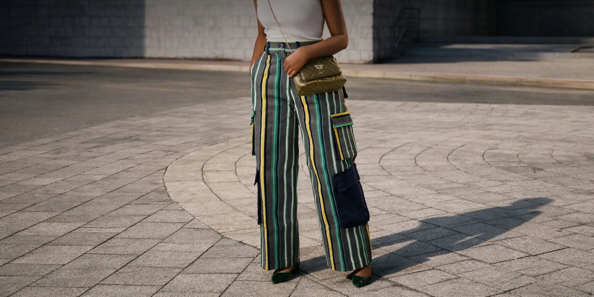 A lady wearing aso oke waistcoat and cargo pants