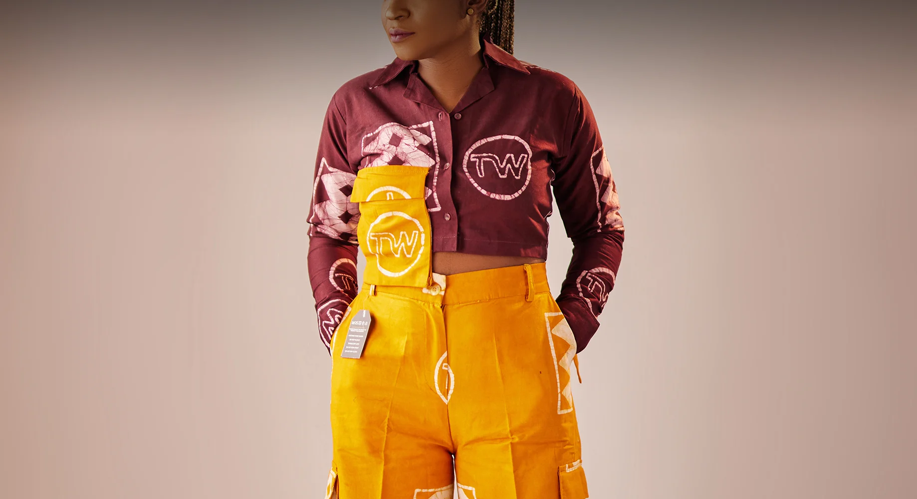 A lady wearing aso oke waistcoat and cargo pants