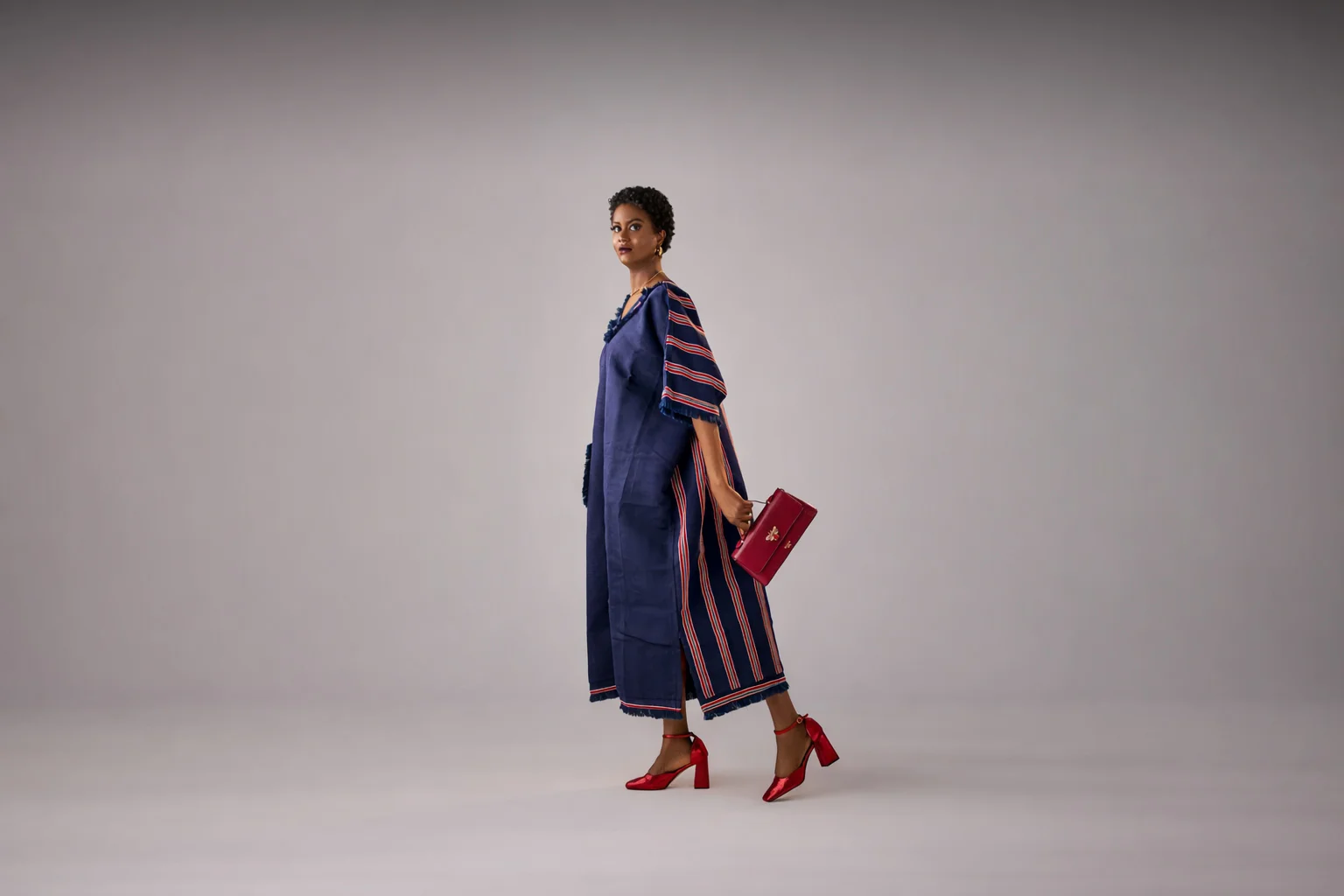 A lady wearing aso oke waistcoat and cargo pants